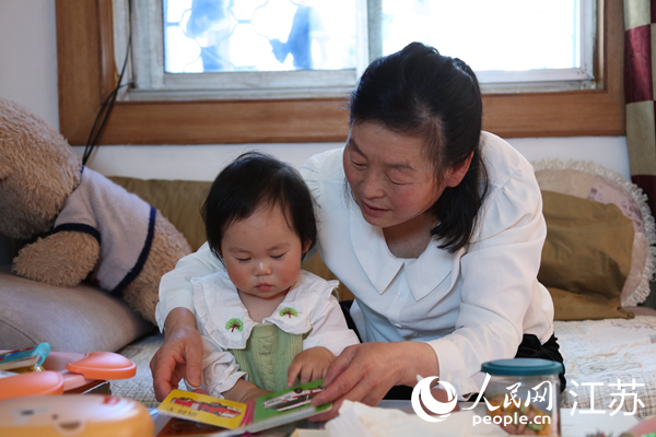 王繼蓮帶孫女看童書(shū)。人民網(wǎng) 冷金明攝