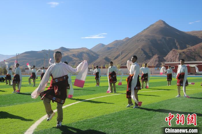 圖為青海師范大學(xué)附屬玉樹實驗學(xué)校學(xué)生在綠茵場跳起囊謙古舞—卓根瑪。　程雨 攝