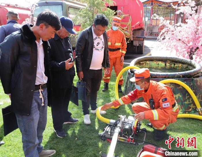 圖為森林消防員為護林員講解滅火裝備的使用方法。　昌都市森林消防支隊 供圖