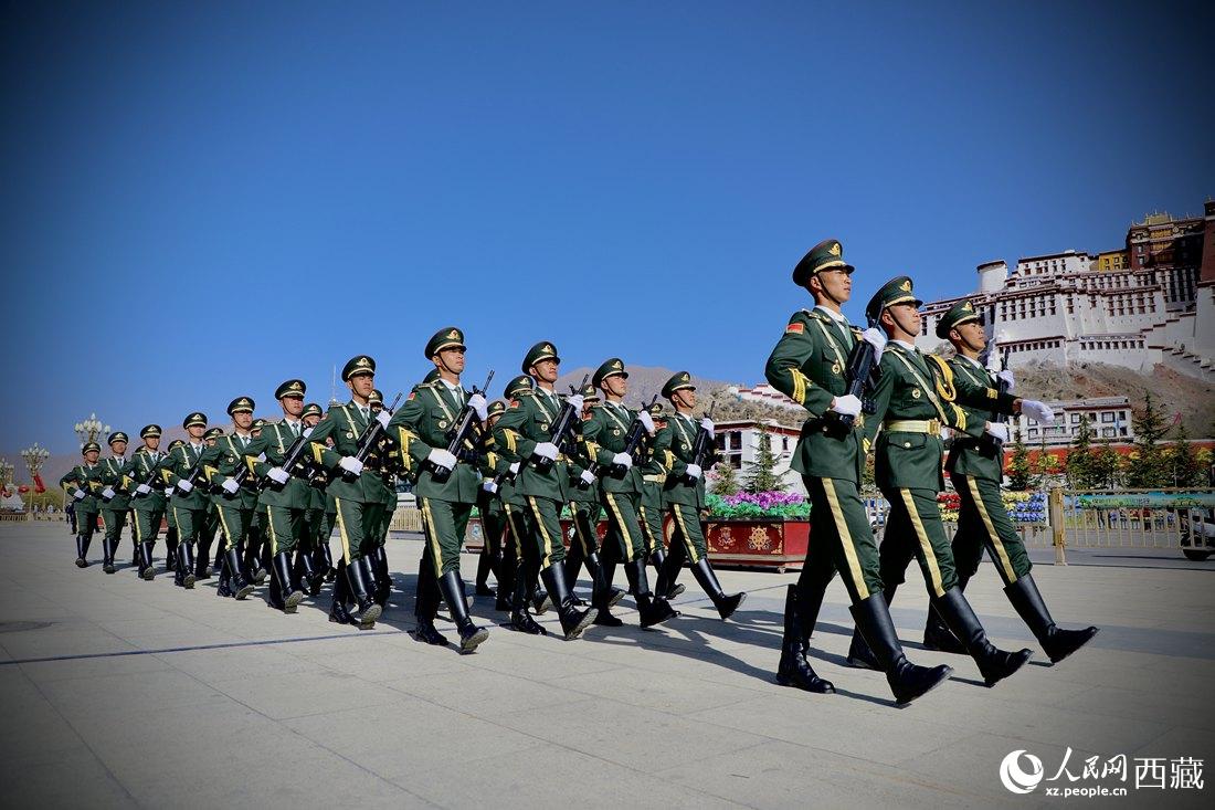 國旗護衛(wèi)隊隊員緊握鋼槍，踏著威武雄壯的步伐，走向國旗臺。人民網(wǎng) 次仁羅布攝